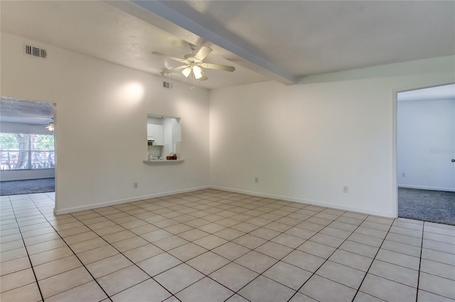 tiled spare room with beamed ceiling and ceiling fan