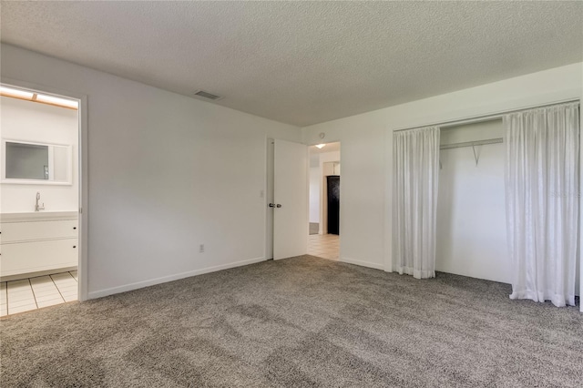 unfurnished bedroom with light carpet and a textured ceiling