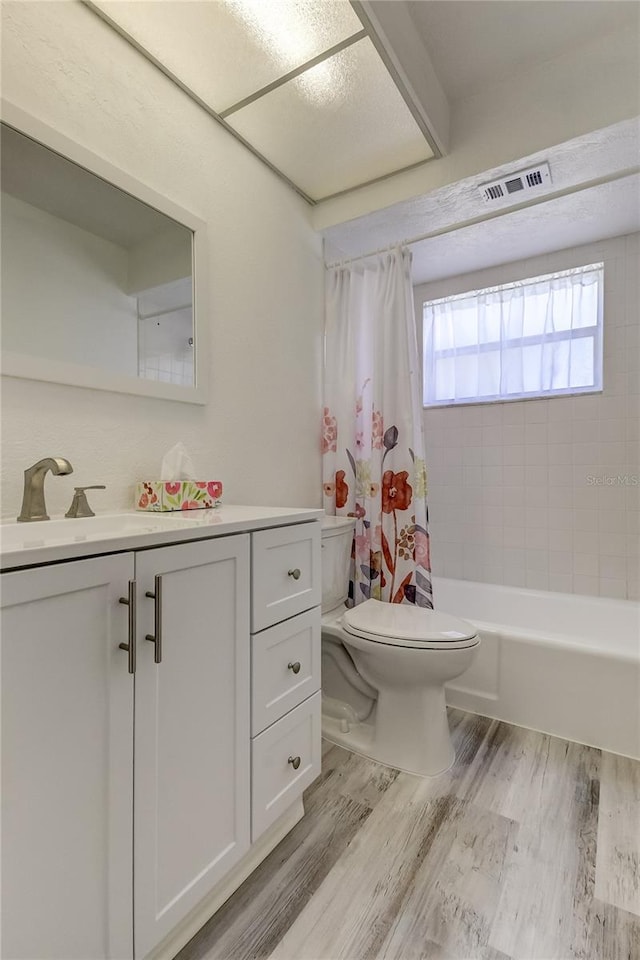 full bathroom with vanity, hardwood / wood-style flooring, toilet, and shower / tub combo