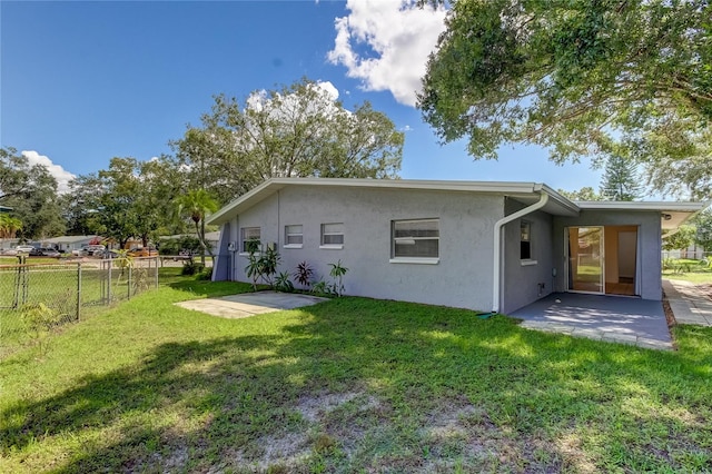 rear view of property with a yard and a patio