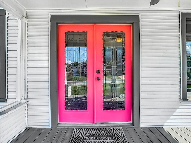 view of exterior entry with a wooden deck and french doors