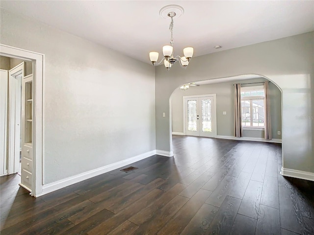 spare room with a chandelier, dark hardwood / wood-style floors, and french doors