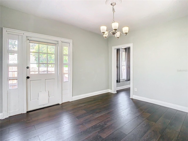 entrance foyer featuring dark wood-type flooring and a notable chandelier