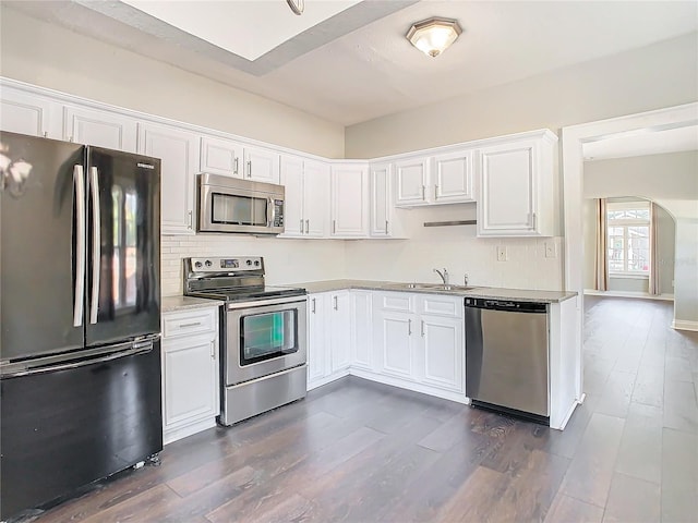 kitchen with white cabinets, sink, stainless steel appliances, and dark wood-type flooring