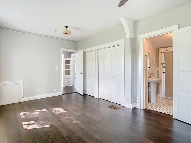 unfurnished bedroom with ensuite bath, ceiling fan, dark hardwood / wood-style floors, and sink