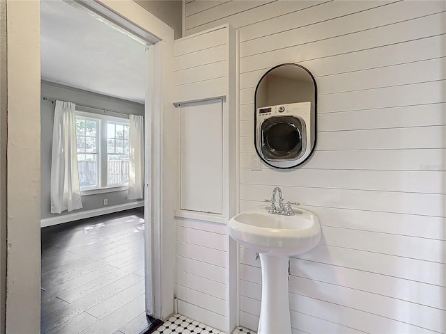 bathroom featuring wood-type flooring and wooden walls