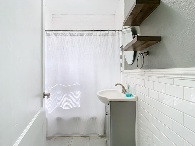 bathroom with tile walls, shower / bath combo, and vanity