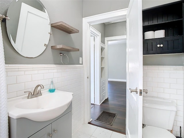 bathroom with vanity, tile walls, hardwood / wood-style floors, and toilet