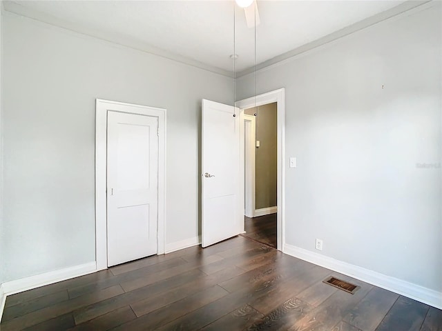 spare room with crown molding, dark hardwood / wood-style floors, and ceiling fan