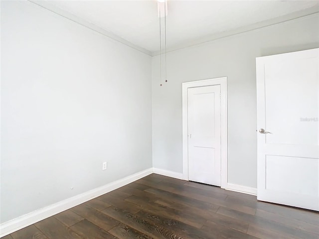 empty room featuring dark hardwood / wood-style floors and crown molding