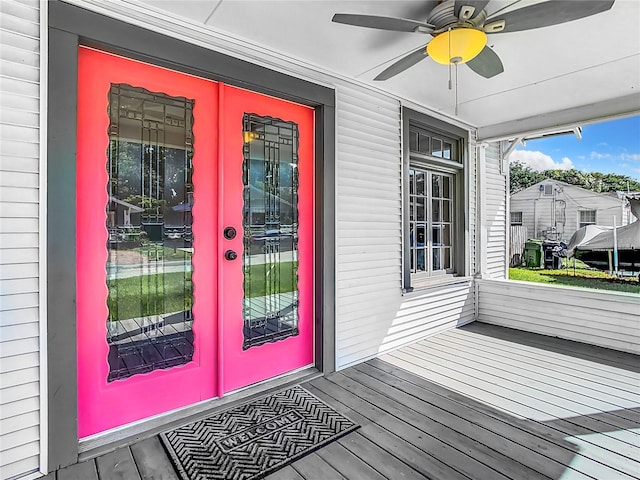 entrance to property with a deck, ceiling fan, and french doors