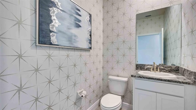 bathroom featuring tile walls, vanity, and toilet