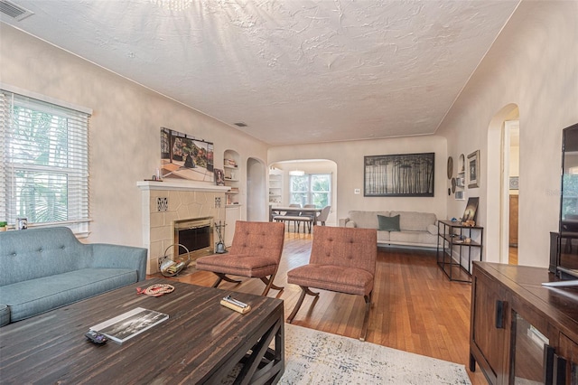 living room featuring a textured ceiling, a healthy amount of sunlight, and wood-type flooring