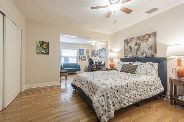 bedroom featuring ceiling fan, a closet, and hardwood / wood-style floors