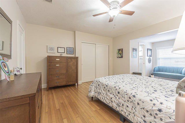 bedroom featuring a closet, light wood-type flooring, and ceiling fan