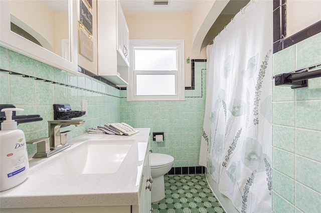 bathroom featuring tile walls, curtained shower, vanity, and toilet