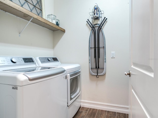 clothes washing area with separate washer and dryer and dark hardwood / wood-style flooring