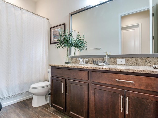 bathroom with a shower with shower curtain, wood-type flooring, vanity, and toilet