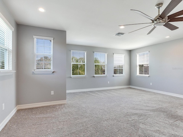 carpeted empty room featuring ceiling fan and plenty of natural light