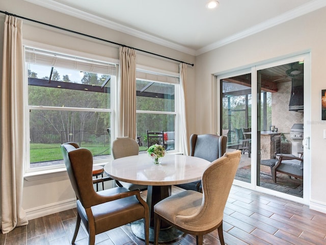 dining room with ornamental molding, hardwood / wood-style floors, and plenty of natural light