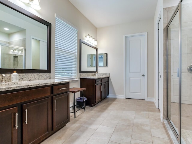 bathroom with a wealth of natural light, vanity, tile patterned flooring, and a shower with shower door