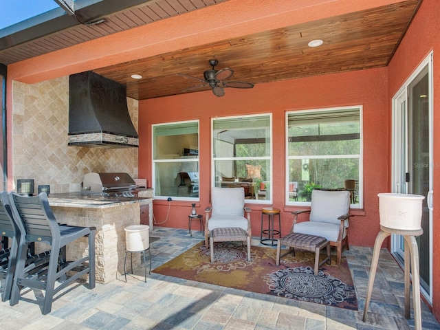 view of patio featuring ceiling fan, an outdoor kitchen, and a grill