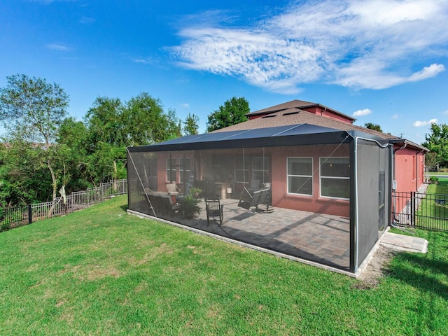 rear view of house with a sunroom and a lawn