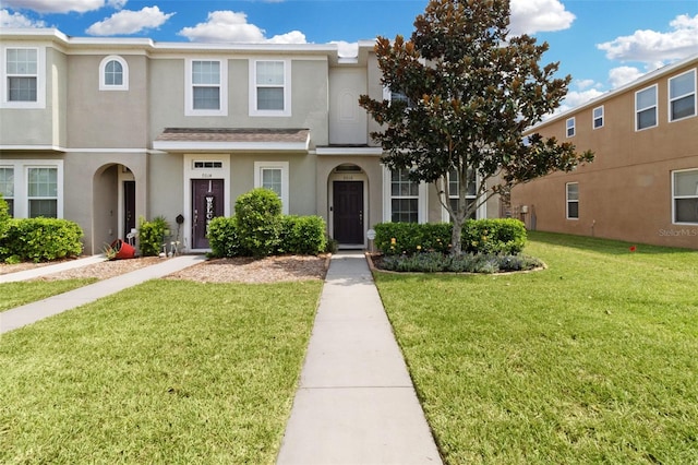 townhome / multi-family property featuring a front yard