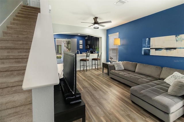 living room with wood-type flooring and ceiling fan