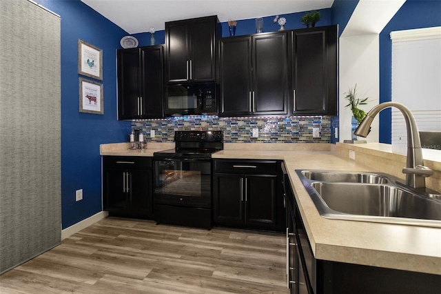 kitchen featuring light wood-type flooring, black appliances, tasteful backsplash, and sink