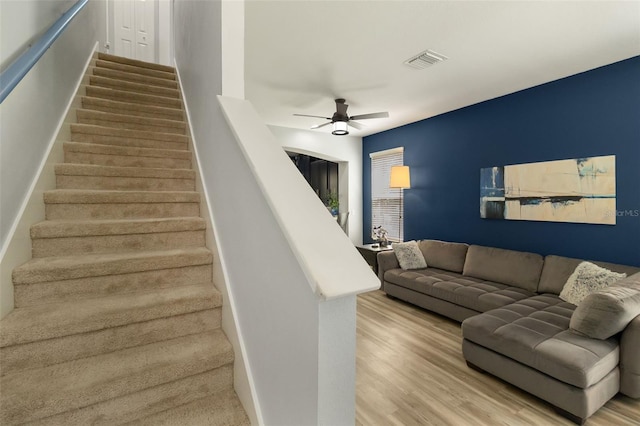 staircase with ceiling fan and hardwood / wood-style flooring