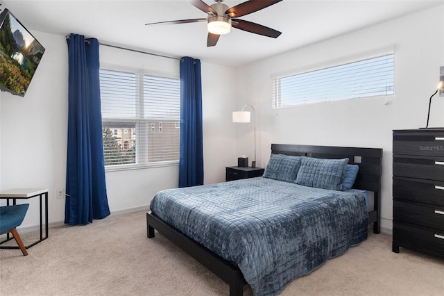 bedroom featuring multiple windows, light carpet, and ceiling fan