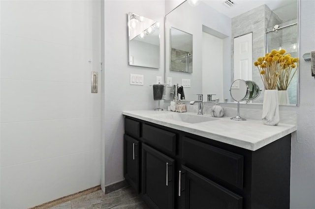 bathroom featuring vanity and a shower with door