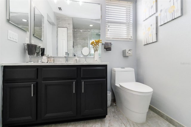 bathroom featuring vanity, toilet, and a shower with door