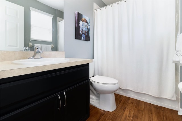 full bathroom featuring shower / bath combo with shower curtain, hardwood / wood-style flooring, vanity, and toilet