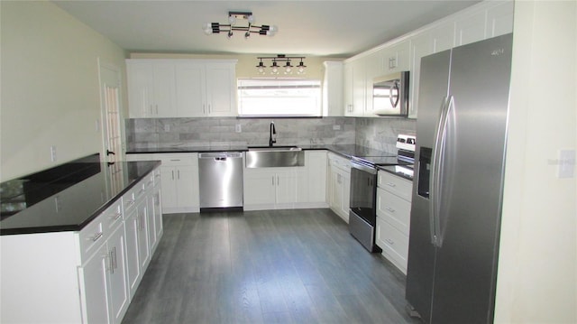 3225 Oakland Rd N, Lakeland, FL 33801 - kitchen with white cabinets, a sink, dark countertops, appliances with stainless steel finishes, and decorative backsplash