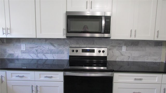 3225 Oakland Rd N, Lakeland, FL 33801 - kitchen featuring appliances with stainless steel finishes, dark countertops, backsplash, and white cabinets