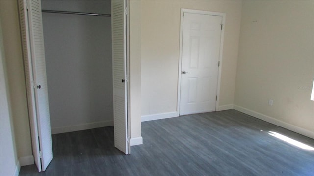 3225 Oakland Rd N, Lakeland, FL 33801 - unfurnished bedroom featuring a closet, dark wood-style flooring, and baseboards