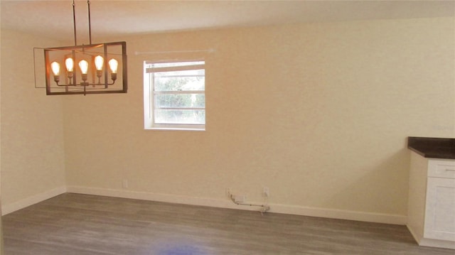 3225 Oakland Rd N, Lakeland, FL 33801 - unfurnished dining area with baseboards, an inviting chandelier, and wood finished floors