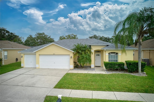 single story home featuring central air condition unit, a front lawn, and a garage