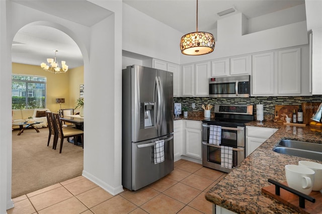 kitchen with light carpet, appliances with stainless steel finishes, decorative backsplash, and pendant lighting