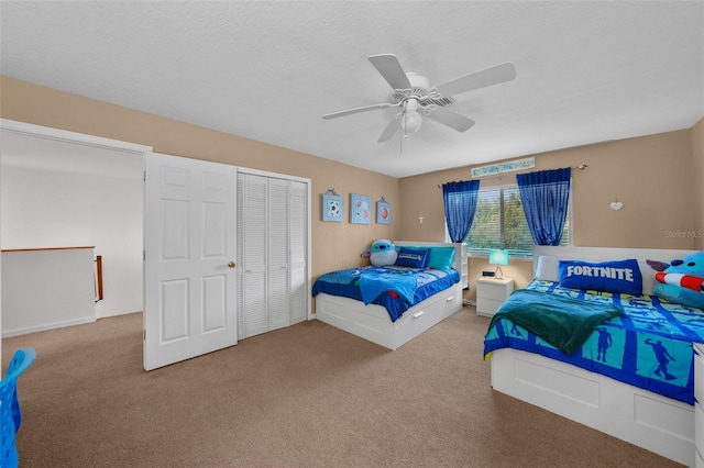 carpeted bedroom featuring ceiling fan, a textured ceiling, and a closet