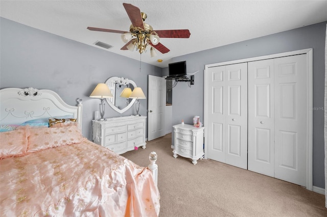 carpeted bedroom with ceiling fan and a closet