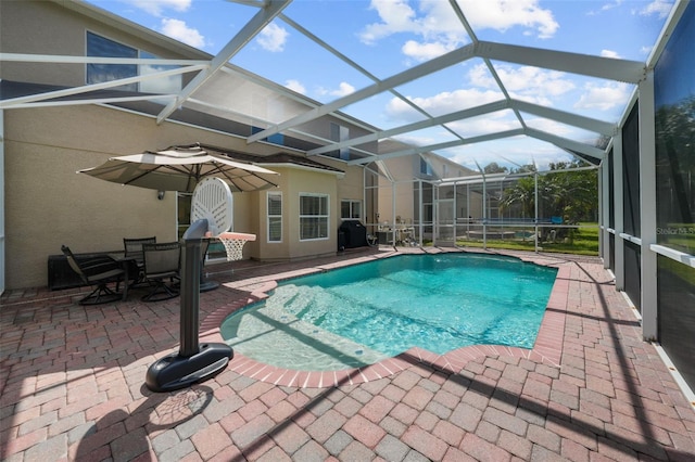 view of swimming pool featuring a lanai, a patio area, and area for grilling