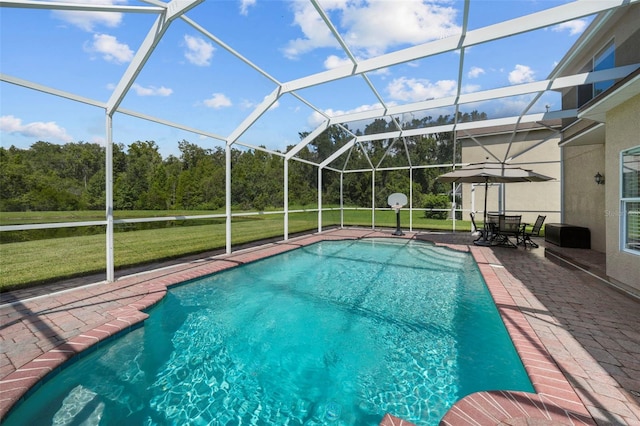 view of swimming pool with glass enclosure, a patio area, and a lawn