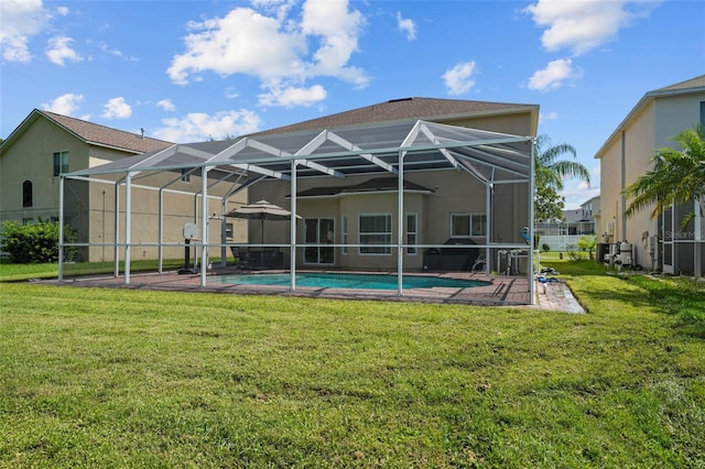 rear view of house with a lanai and a lawn