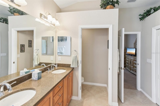 bathroom with vanity, vaulted ceiling, toilet, and tile patterned floors