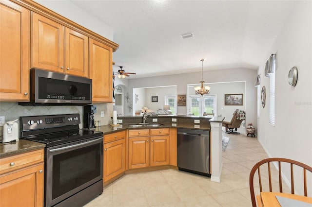 kitchen featuring kitchen peninsula, stainless steel appliances, vaulted ceiling, decorative backsplash, and light tile patterned floors