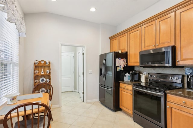 kitchen with stainless steel appliances, backsplash, dark stone countertops, vaulted ceiling, and light tile patterned flooring