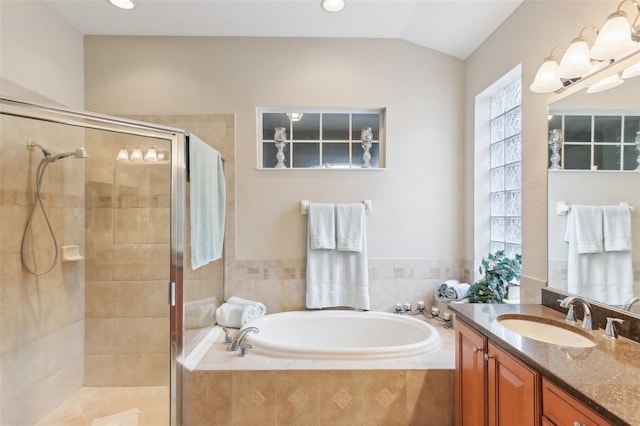 bathroom with vanity, vaulted ceiling, and separate shower and tub